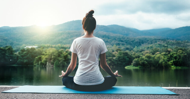 Full Length Of Woman Doing Yoga Against Lake
