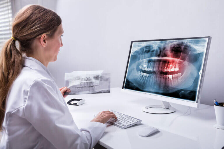 Female dentist reviewing panoramic x-ray image on a computer