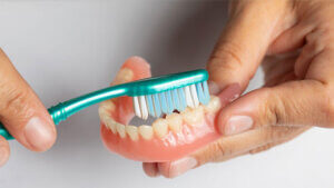 cleaning a denture with denture brush